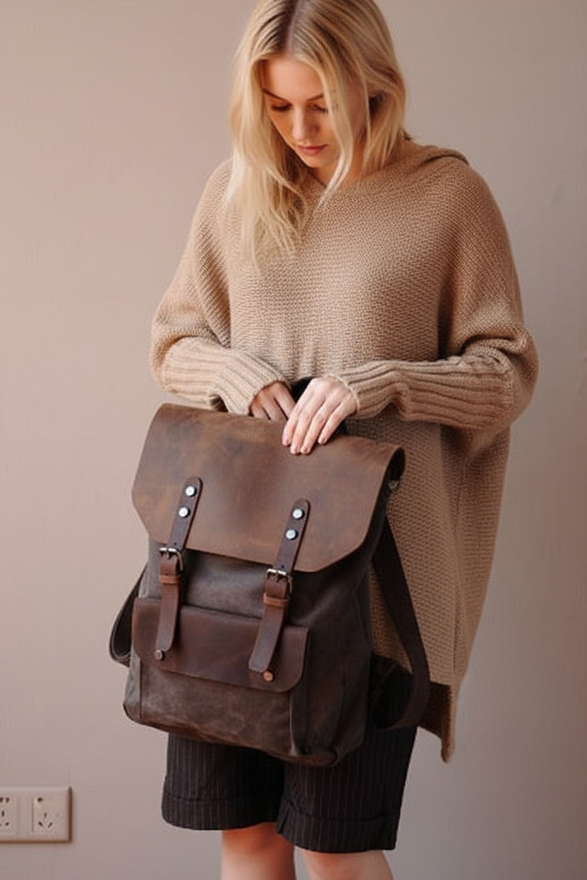 braunem Canvas-Rucksack mit Lederklappe und Schnallen von VINTAGE TAR, getragen vom Model in einem beigen Pullover, Vorderansicht