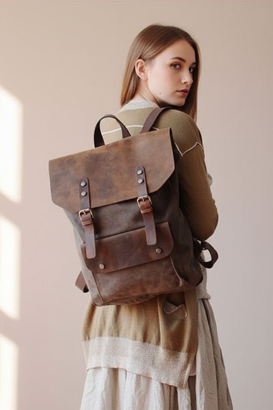 Brauner Rucksack aus Canvas mit Lederdetails von VINTAGE TAR, hier von hinten am Model abgebildet, mit Klappenverschluss und Messingschnallen.
