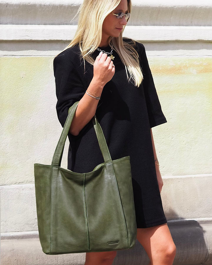 Woman carrying a green shopper bag made of Italian calf leather in casual setting