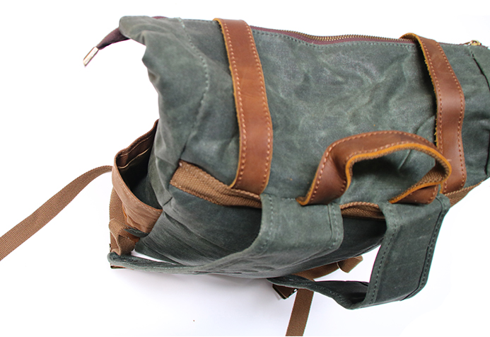 Detailaufnahme des Vintage Rucksacks in Türkisgrün mit Fokus auf die hochwertigen Echtleder-Verschlüsse, robuste Metall-Schnallen und die gewachste Canvas-Struktur mit charakteristischen Knicklinien