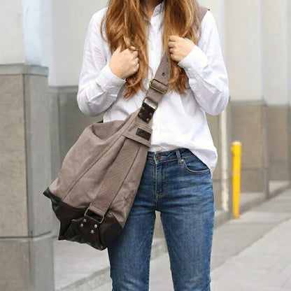 Blonde Frau in weißer Leinenbluse und blauen Jeans trägt die khakibraune Canvas Schultertasche lässig über der Schulter auf einer städtischen Straße.
