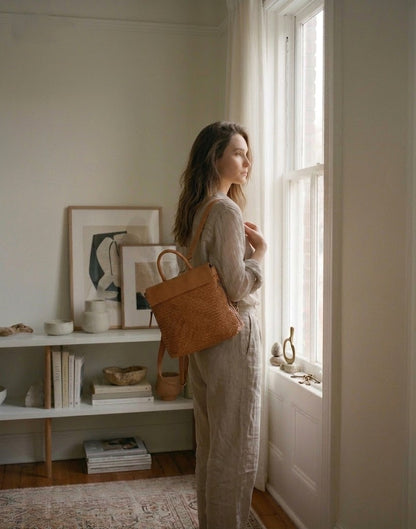 Lifestyle-foto: Kometente Business-Frau trägt den cognac braun Lederrucksack als elegante Schultertasche über dem Arm