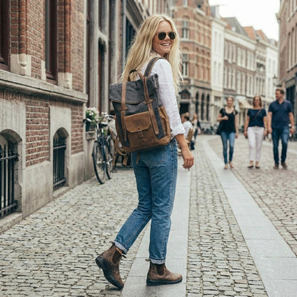 Lifestyle-Szene mit dem dunkelgrauen Vintage Rucksack Canvas & Leder platziert auf einem Tisch im Outdoor, moderner Business-Look für Damen und Herren, stilvolles Zubehör für urbane Reisen