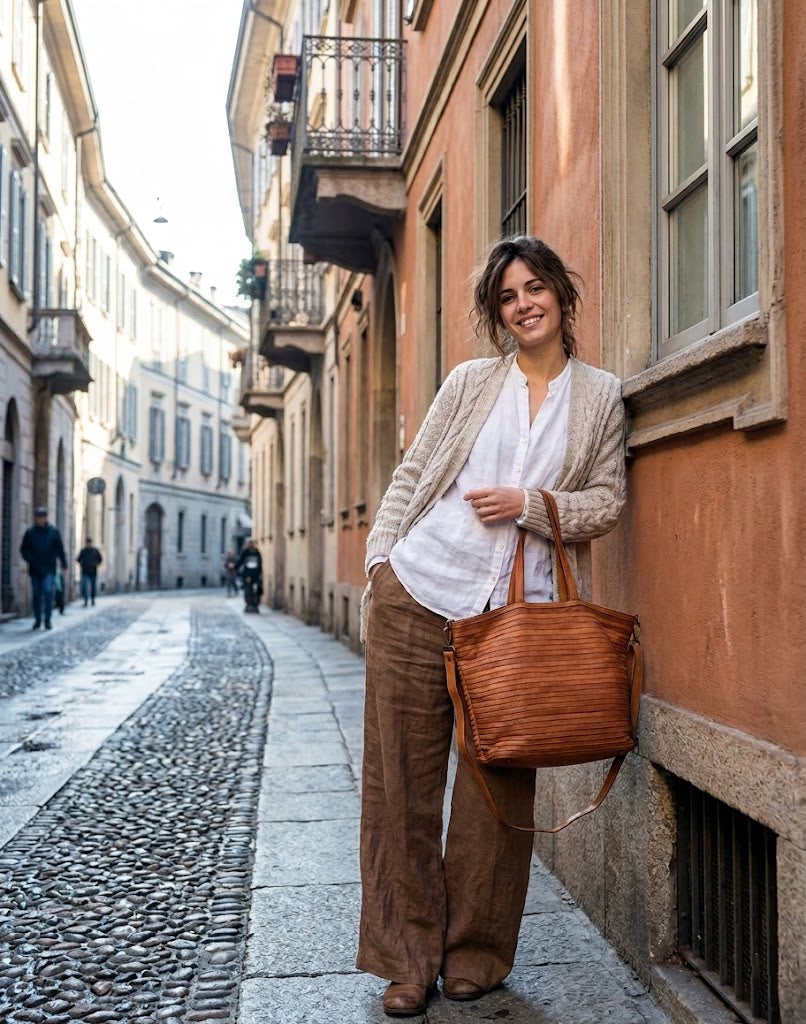 Studentin mit der großen Shopper Handtasche aus Leder in Schwarz, genutzt als praktische und elegante Unitasche für Laptop und Hefte.