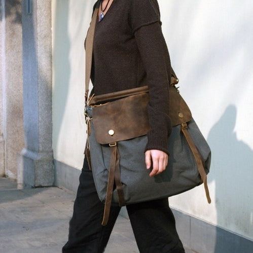 Grau Crossbody Hobo-Umhängetasche aus Canvas und Leder mit verstellbarem Schultergurt, getragen von einer Frau im minimalistischen Casual-Look Casual-Look.  