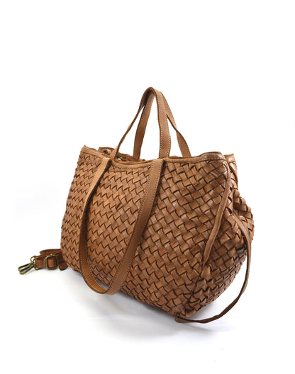 Three-quarter view of the cognac-colored YOTTI shoulder bag made of braided genuine leather. The perspective shot shows the spatial depth, the volume of the shopper, and the elegant transition from the front to the side.